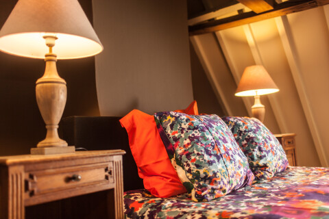 Tweepersoonsboxspring onder 18de eeuwse balken